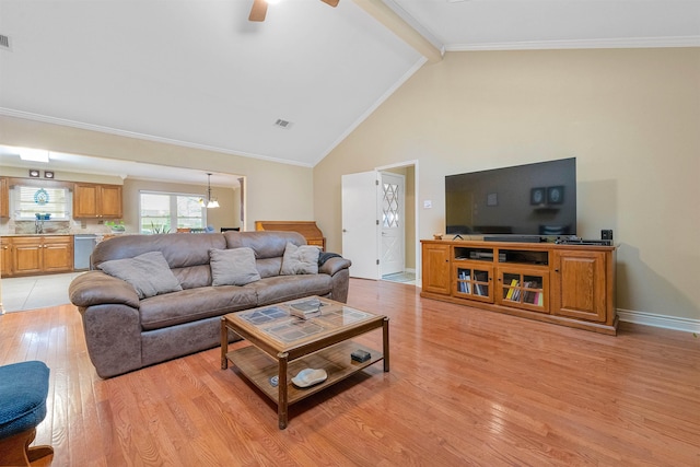 living room with ornamental molding, beamed ceiling, and light wood-style flooring