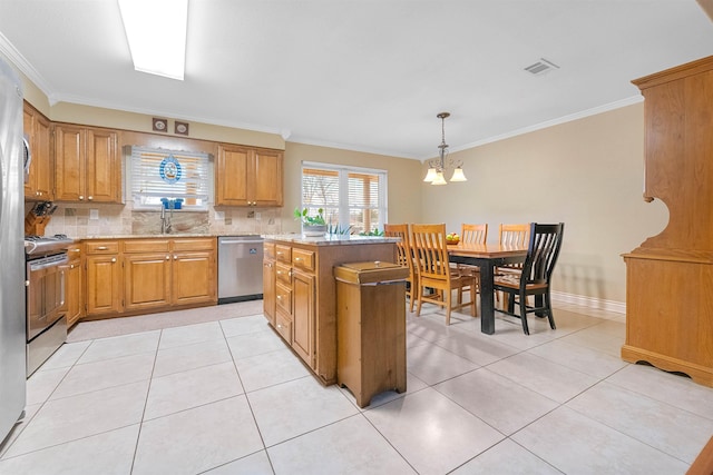 kitchen featuring stainless steel appliances, light countertops, visible vents, and a center island