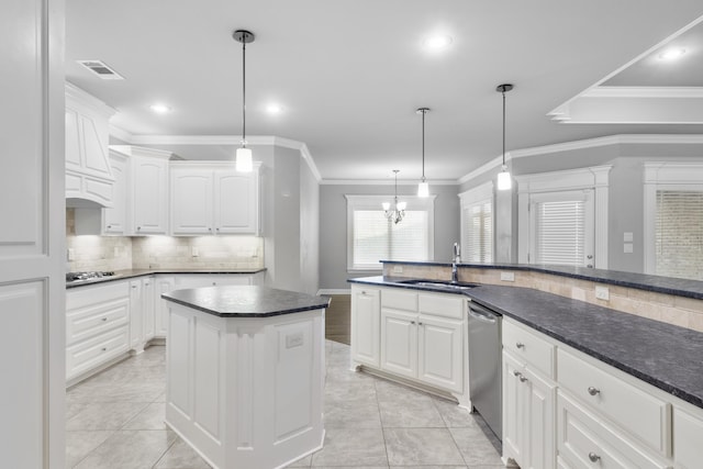 kitchen featuring dark countertops, pendant lighting, white cabinets, and a sink