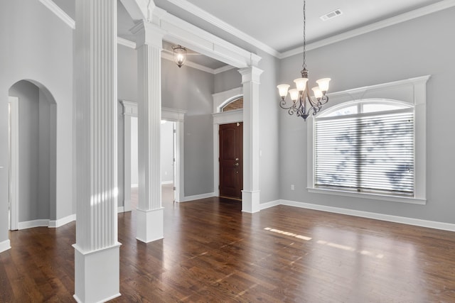 spare room with arched walkways, dark wood-style flooring, visible vents, and ornate columns