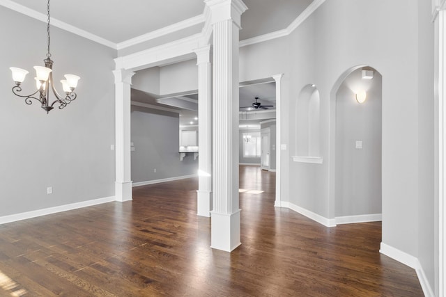 unfurnished dining area with baseboards, a ceiling fan, dark wood-type flooring, crown molding, and ornate columns