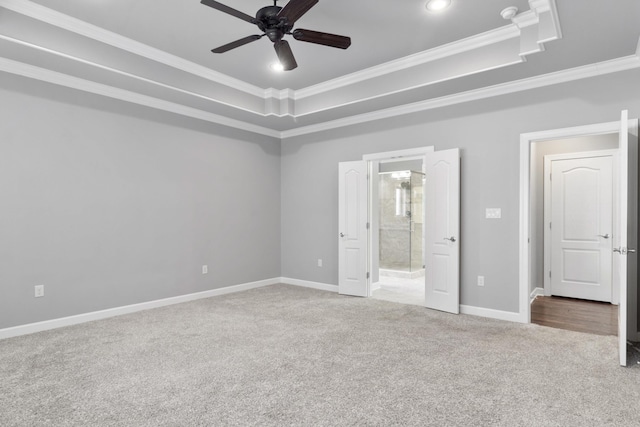 unfurnished bedroom featuring ornamental molding, a raised ceiling, and carpet flooring