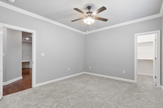 spare room featuring baseboards, ceiling fan, carpet flooring, and crown molding