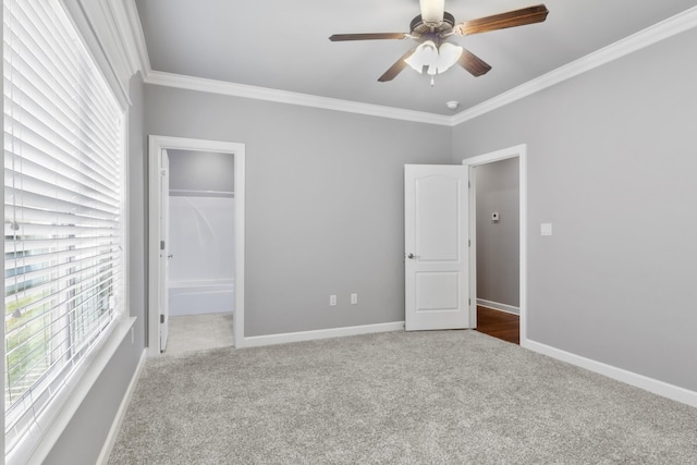 unfurnished bedroom featuring baseboards, a closet, carpet, and crown molding