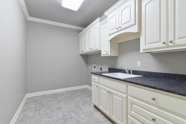 laundry area with hookup for a washing machine, crown molding, baseboards, and a sink