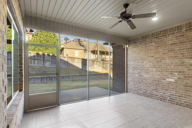 unfurnished sunroom featuring ceiling fan