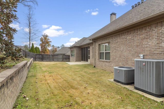 view of yard featuring a fenced backyard, central AC, and a patio