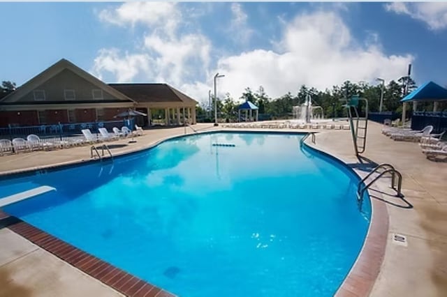 pool with a patio and fence