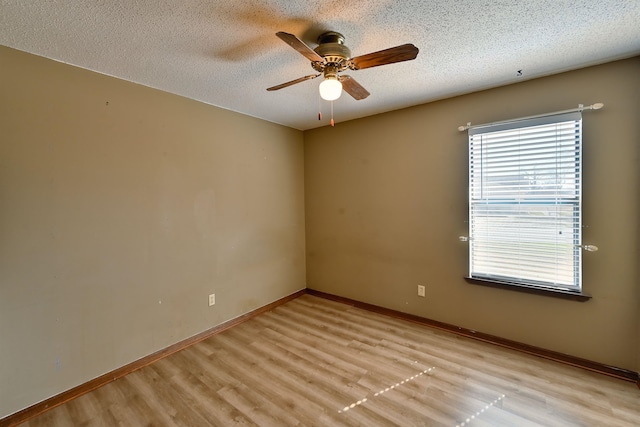 unfurnished room featuring light wood-type flooring, a textured ceiling, and baseboards