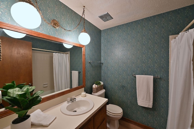 full bath featuring toilet, a textured ceiling, vanity, and wallpapered walls