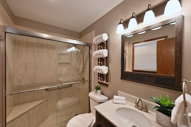 bathroom with toilet, a shower stall, and vanity