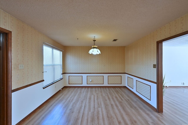 interior space featuring wallpapered walls and a textured ceiling