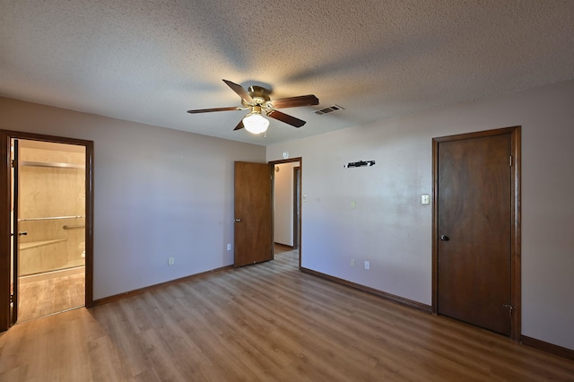 unfurnished bedroom with light wood finished floors, baseboards, visible vents, and a textured ceiling