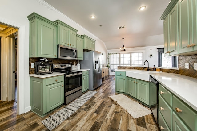 kitchen with appliances with stainless steel finishes, light countertops, decorative backsplash, and green cabinets