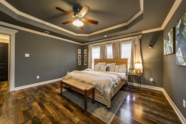 bedroom featuring baseboards, visible vents, dark wood-style floors, ornamental molding, and a tray ceiling