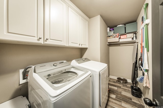 laundry room with separate washer and dryer, dark wood-type flooring, cabinet space, and baseboards