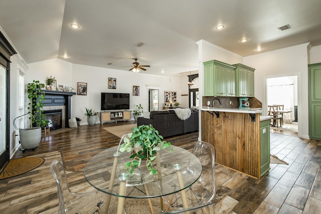 dining space featuring dark wood-style floors, plenty of natural light, a fireplace, and visible vents