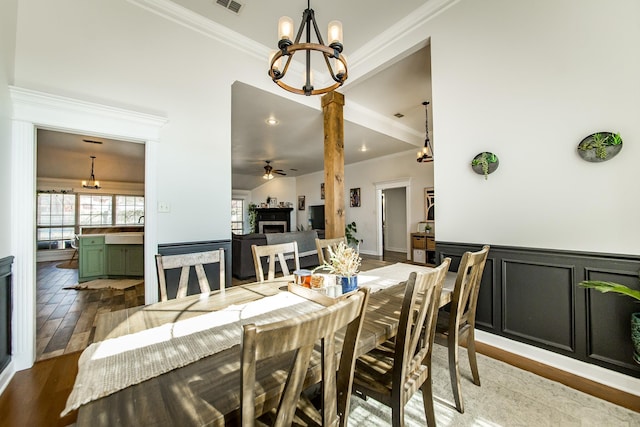 dining space featuring crown molding, a fireplace, and wood finished floors