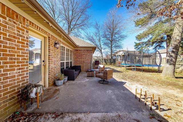 view of patio featuring a trampoline and fence