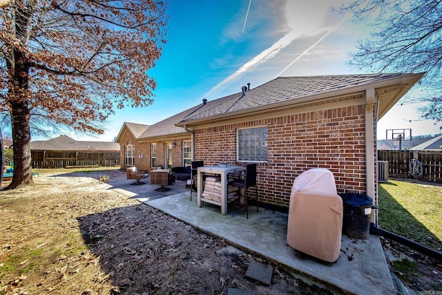 back of property with a patio area, a fenced backyard, and brick siding