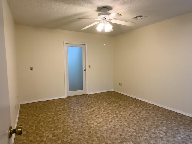 spare room featuring visible vents, ceiling fan, a textured ceiling, and baseboards