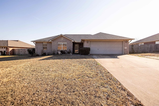 single story home with concrete driveway, roof with shingles, an attached garage, fence, and brick siding