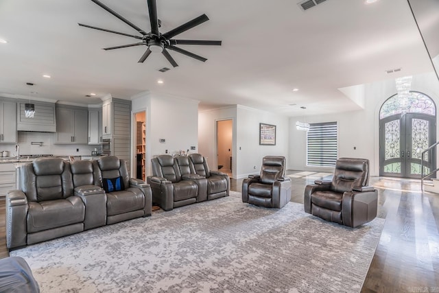 living area with french doors, crown molding, recessed lighting, ceiling fan, and wood finished floors