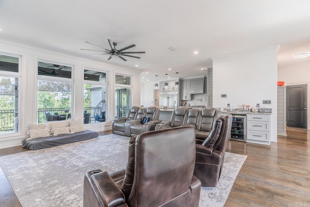 living room featuring beverage cooler, a wealth of natural light, and crown molding