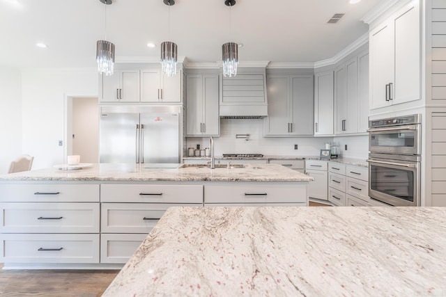 kitchen with tasteful backsplash, visible vents, light stone counters, hanging light fixtures, and stainless steel appliances