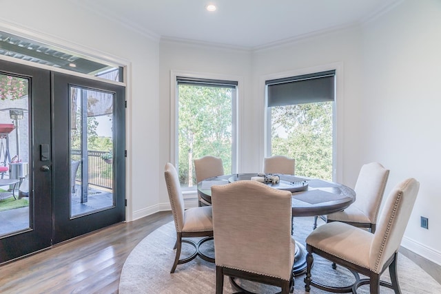 dining area featuring baseboards, ornamental molding, wood finished floors, and french doors