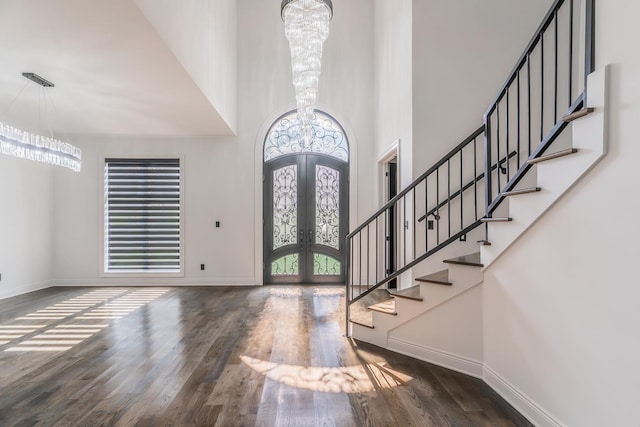 entryway featuring baseboards, dark wood-style flooring, stairs, french doors, and a notable chandelier