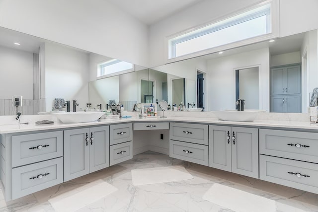 bathroom featuring double vanity, marble finish floor, and a sink