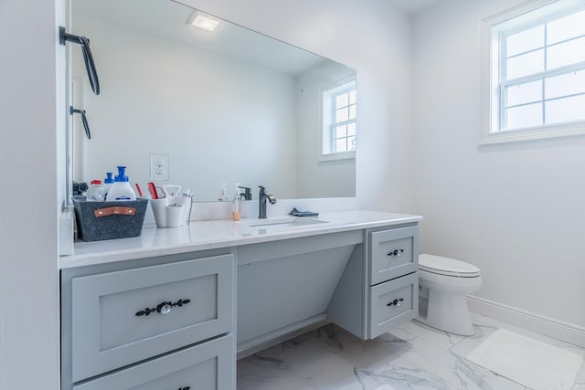 bathroom with toilet, marble finish floor, baseboards, and vanity