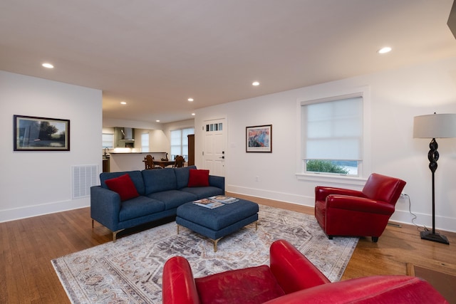 living area with light wood-style floors, recessed lighting, visible vents, and baseboards