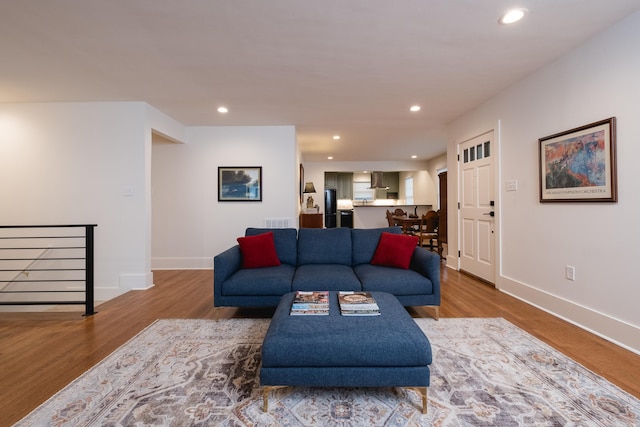 living area featuring baseboards, wood finished floors, and recessed lighting