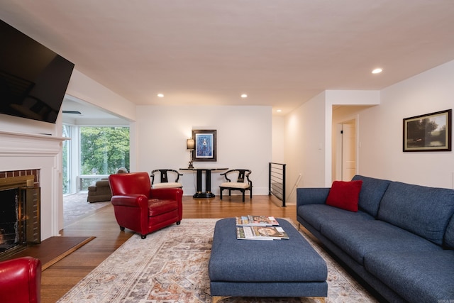 living room with baseboards, a fireplace, wood finished floors, and recessed lighting