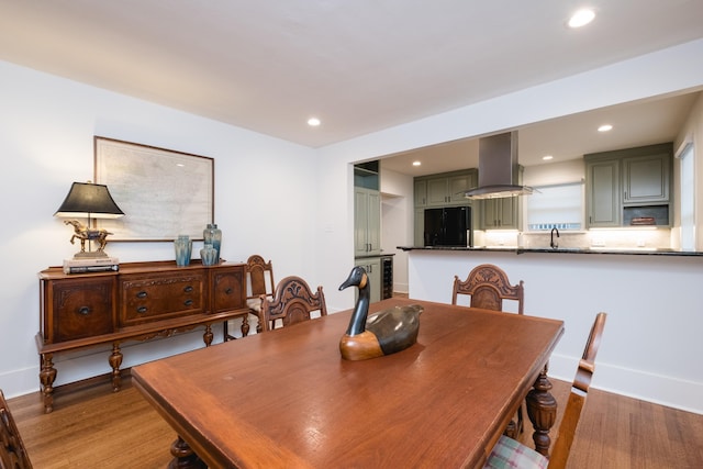 dining room featuring baseboards, wood finished floors, and recessed lighting