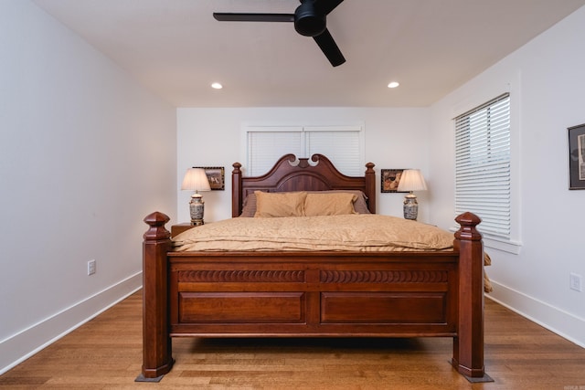 bedroom with recessed lighting, wood finished floors, and baseboards