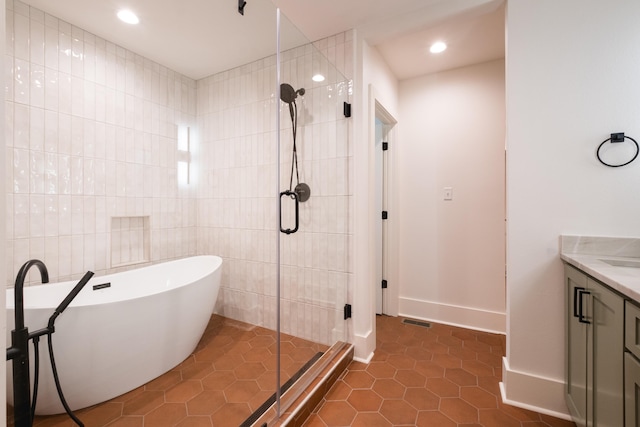 full bathroom featuring a stall shower, visible vents, tile patterned flooring, a freestanding tub, and tile walls