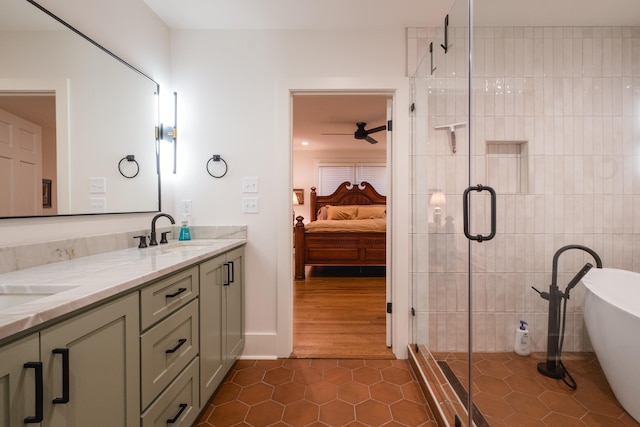 ensuite bathroom featuring a stall shower, a soaking tub, tile patterned floors, ensuite bathroom, and a sink