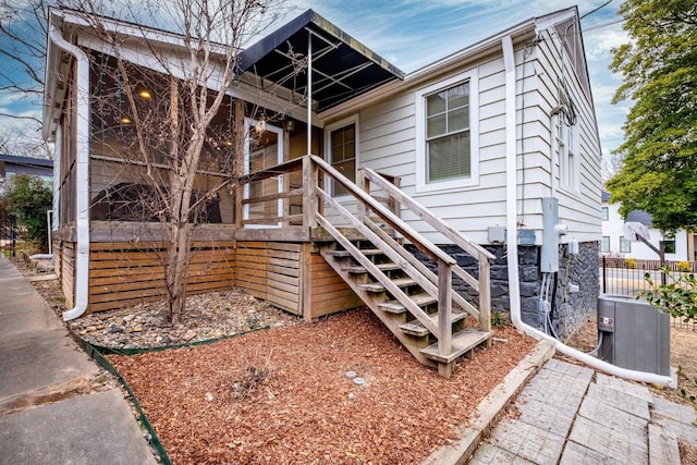 view of front facade featuring stairway, cooling unit, and fence