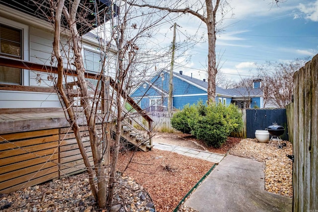 view of yard with fence and stairway