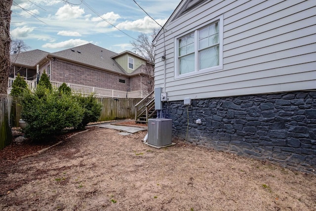 view of yard featuring central air condition unit and fence