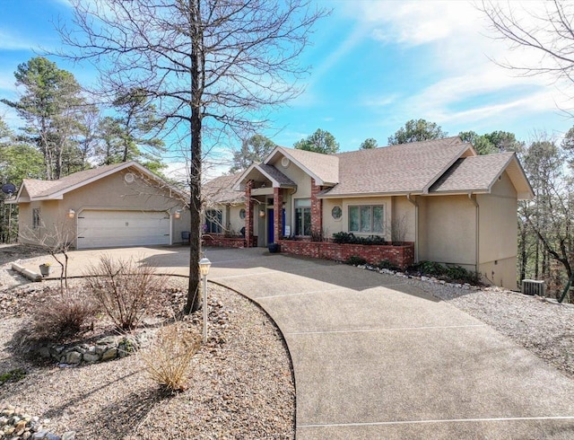 single story home with concrete driveway, a shingled roof, an attached garage, and stucco siding