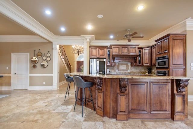 kitchen featuring a large island, light stone counters, stainless steel appliances, and a breakfast bar area