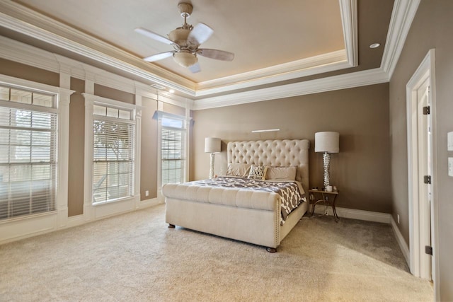 bedroom featuring baseboards, a raised ceiling, light colored carpet, ceiling fan, and ornamental molding