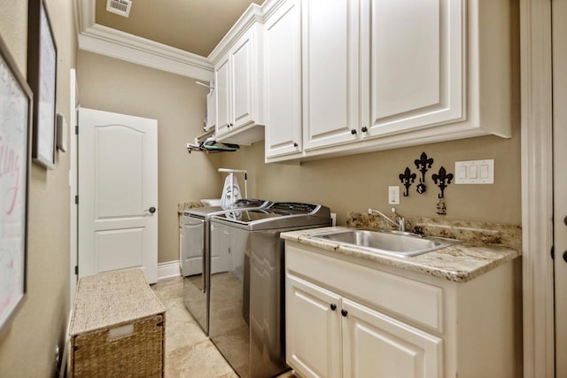 laundry area with crown molding, cabinet space, a sink, independent washer and dryer, and baseboards