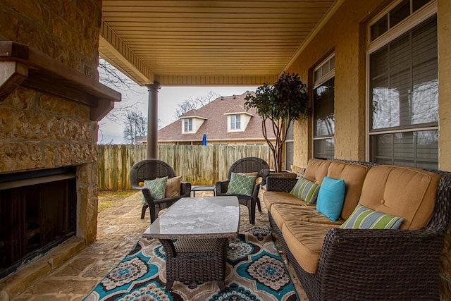 view of patio featuring fence and an outdoor living space with a fireplace