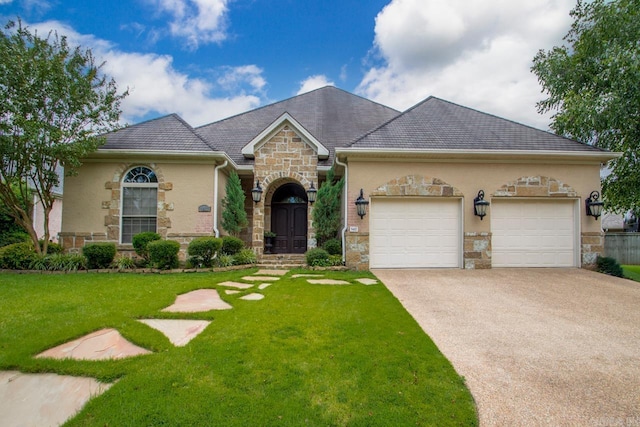 view of front facade with an attached garage, driveway, a front lawn, and stone siding