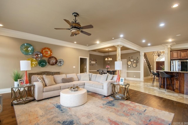 living area featuring ornate columns, wood finished floors, and recessed lighting